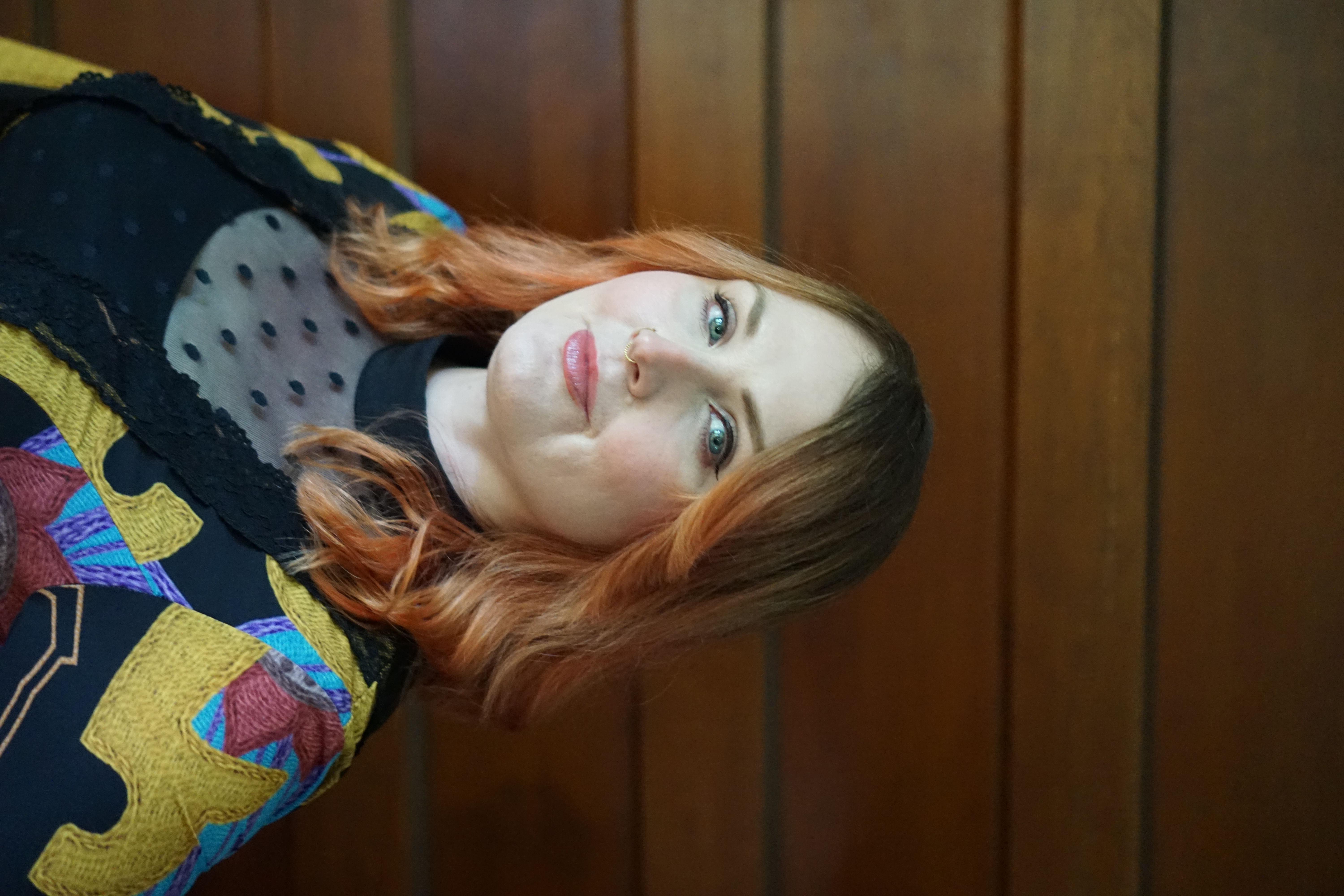 Lauren Hunter, founder of Lauren Hunter Design, standing in front of a wood-paneled wall